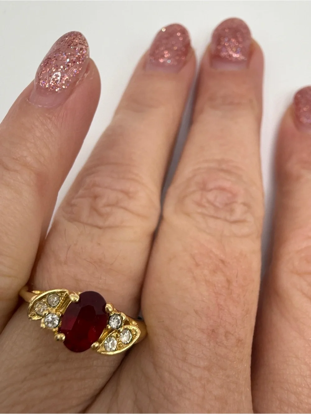 Gold Ring with Oval Red Center Stone and Clear Accent Stones